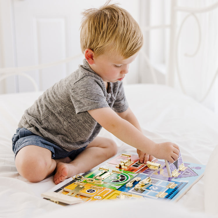 A kid playing with The Melissa & Doug Latches Wooden Activity Board