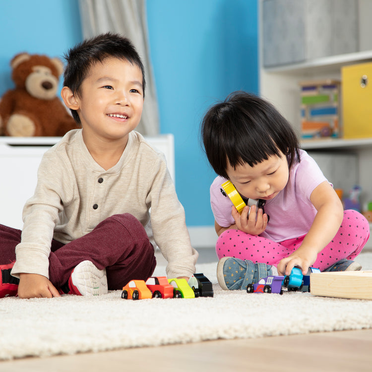 A child on white background with The Melissa & Doug Wooden Cars Vehicle Set in Wooden Tray