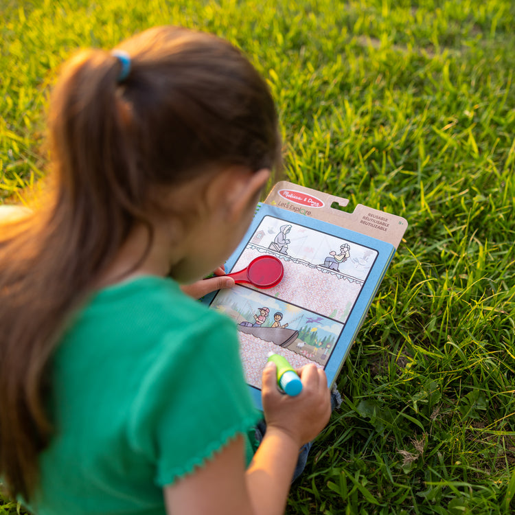 A kid playing with The Melissa & Doug Let’s Explore Water Wow! Outdoor Adventure Deluxe Water-Reveal Pad – Reusable On The Go Travel Activity