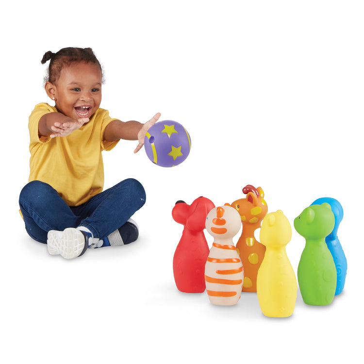 A child on white background with The Melissa & Doug K's Kids Bowling Friends Play Set and Game With 6 Pins and Convenient Carrying Case