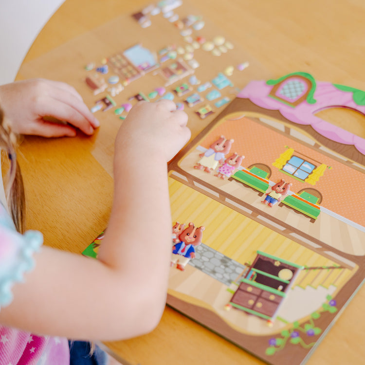 A kid playing with The Melissa & Doug Puffy Sticker Activity Books Set - Farm, Safari, and Chipmunk