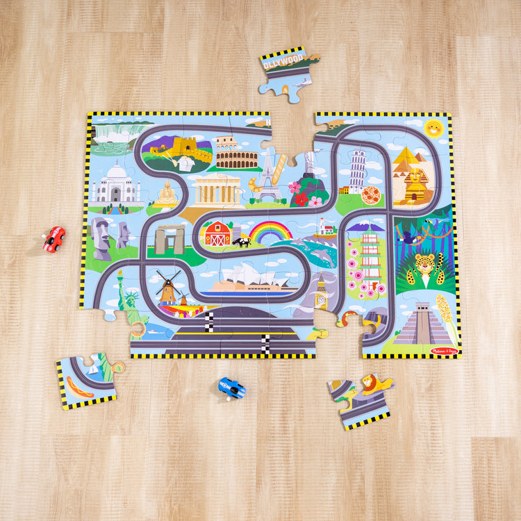 A playroom scene with The Melissa & Doug Race Around the World Tracks Cardboard Jigsaw Floor Puzzle and Wind-Up Vehicles – 48 Pieces, for Boys and Girls 3+