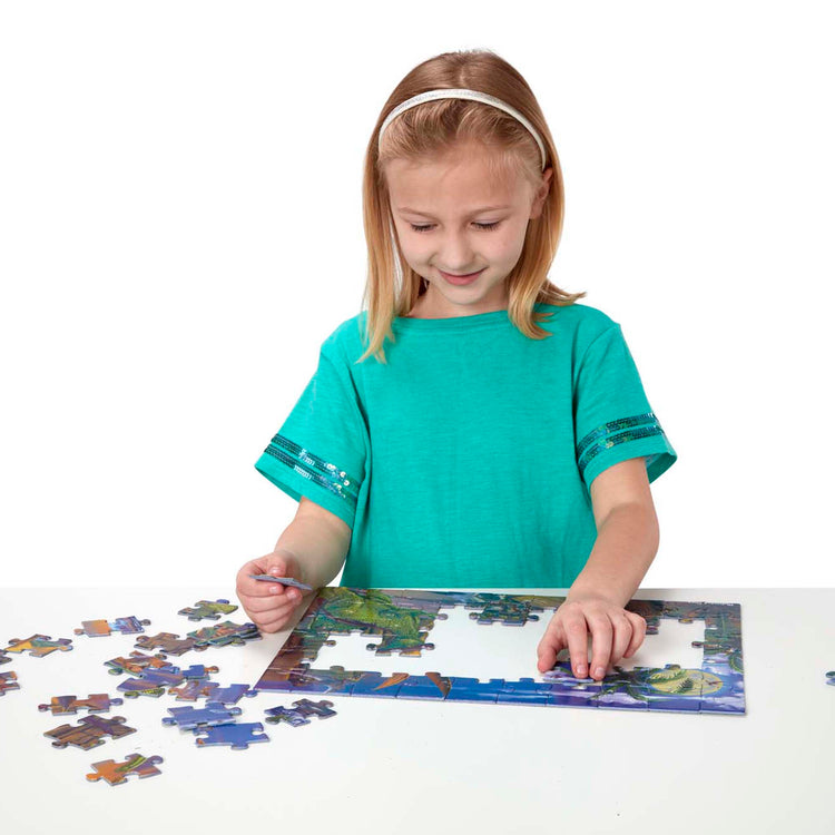 A child on white background with The Melissa & Doug Land of Dinosaurs Jigsaw Puzzle (60 pcs)