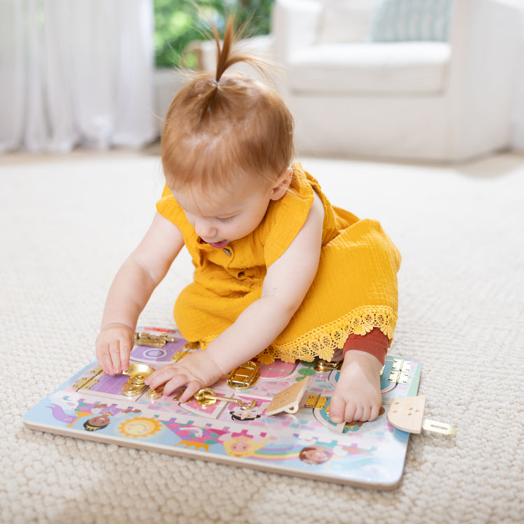 A kid playing with The Melissa & Doug Castle Latches Board with 6 Brass-Plated Doors and Locks - Wooden Sensory Toy for Ages 3+
