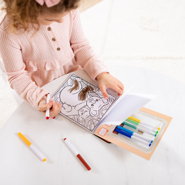 A kid playing with The Magic-Pattern Kids’ Wild Animals Marker Coloring Pad On the Go Travel Activity