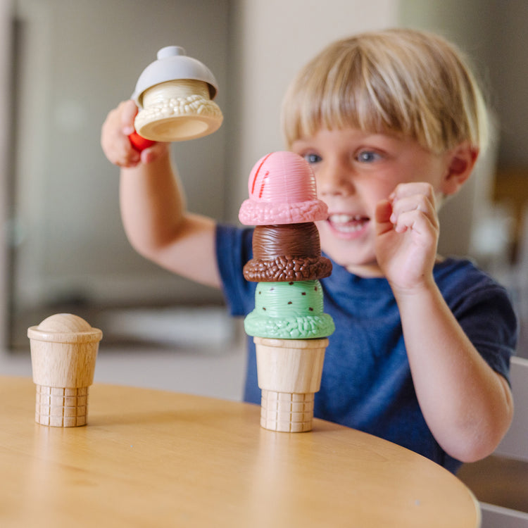A kid playing with The Melissa & Doug Scoop and Stack Ice Cream Cone Magnetic Pretend Play Set, Multicolor
