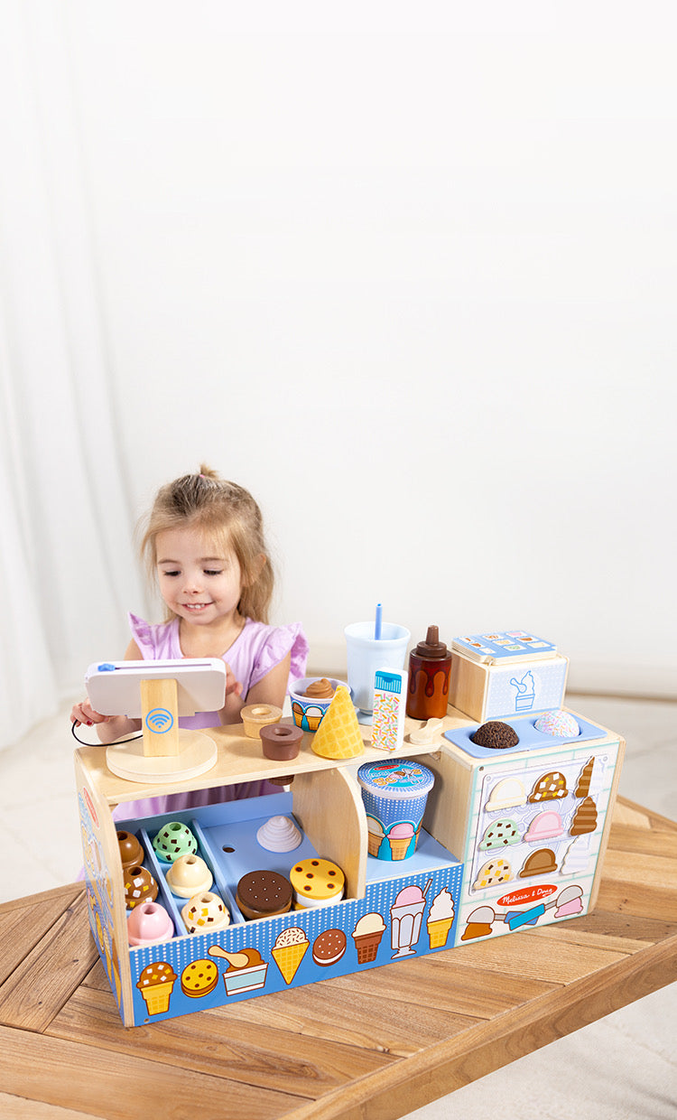 Child playing with Cool Scoops Ice Creamery wooden play counter
