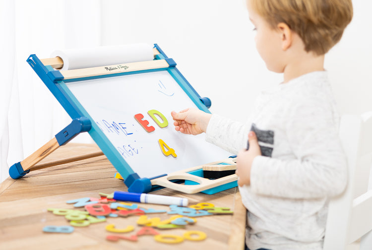 child playing with deluxe double-sided tabletop easel