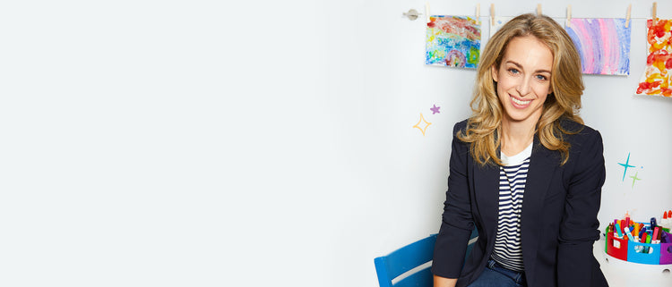 Headshot of Dr. Becky sitting in a room with children's finger painting art behind her