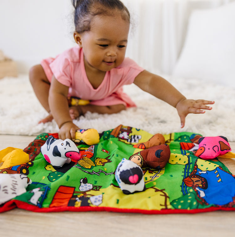child playing with soft farm animals toy