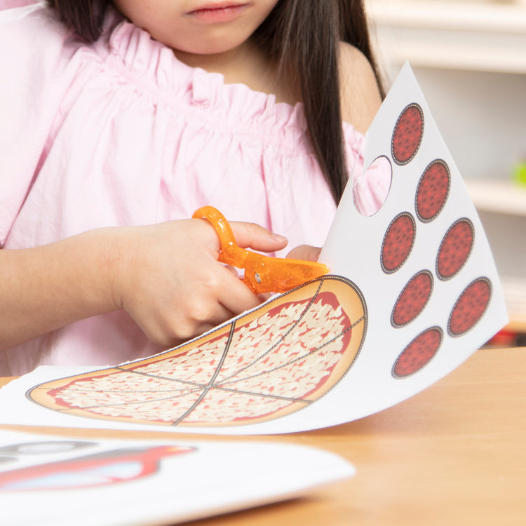 A kid playing with The Melissa & Doug Scissor Skills and Tape Activity Books Set