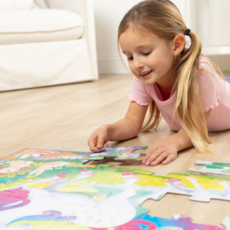 A kid playing with The GID Unicorn Floor Puzzle