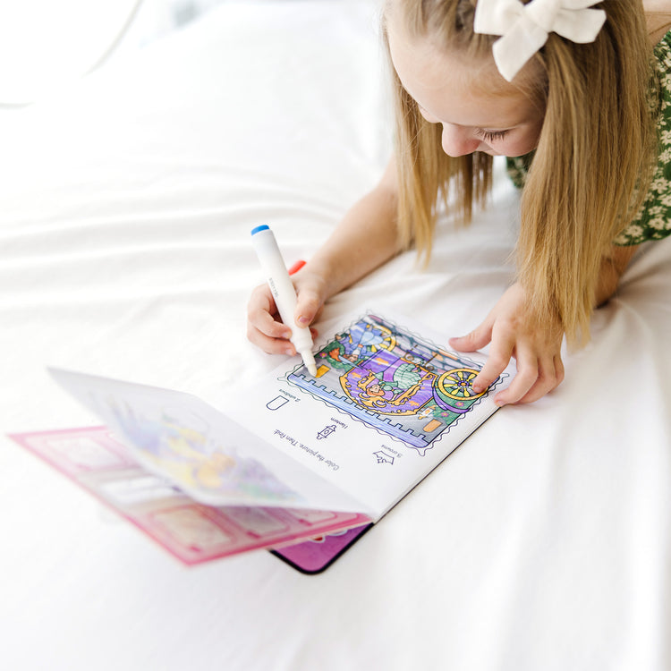 A kid playing with The Melissa & Doug On the Go ColorBlast! Activity Book - Princess (24 Pages)