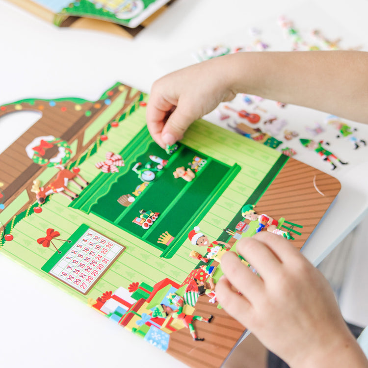 A kid playing with The Puffy Stickers Bundle - Santa's Workshop & 'Tis the Season