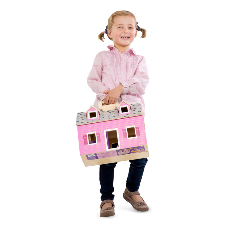 A child on white background with The Melissa & Doug Fold and Go Wooden Dollhouse With 2 Dolls and Wooden Furniture