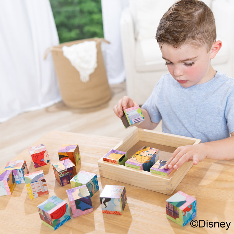 A kid playing with The Melissa & Doug Disney Princess Wooden Toy Cube Puzzle Blocks for Boys and for Girls 3+