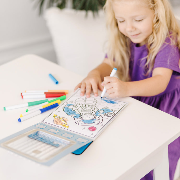 A kid playing with The Melissa & Doug Magic-Pattern Kids’ Adventure Marker Coloring Pad On the Go Travel Activity