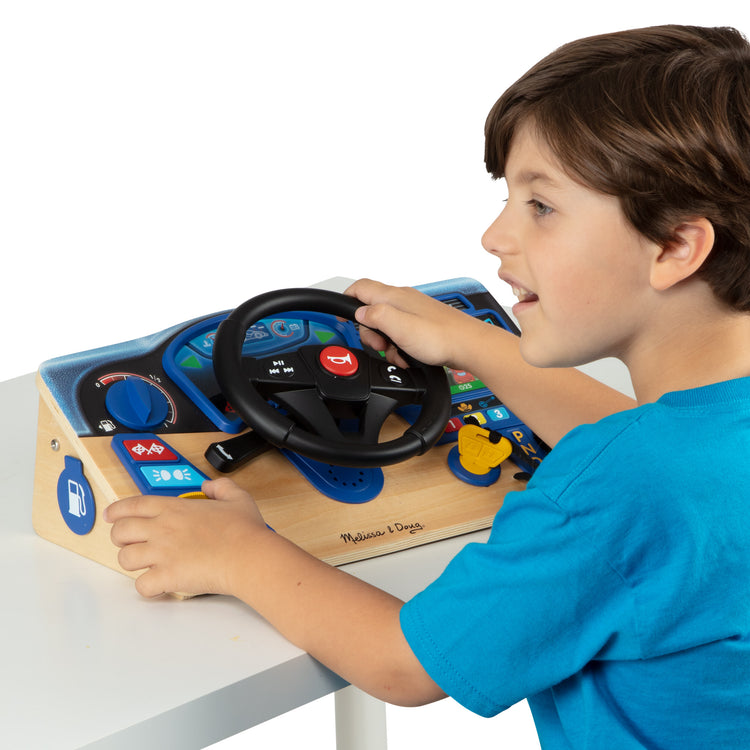A child on white background with The Melissa & Doug Vroom & Zoom Interactive Wooden Dashboard Steering Wheel Pretend Play Driving Toy