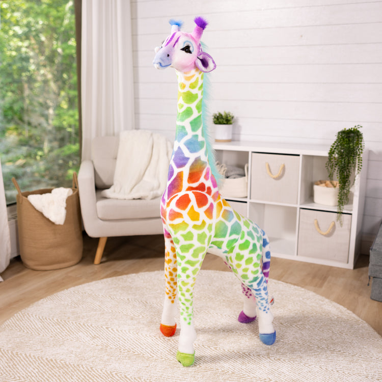 A playroom scene with The MelissaAndDoug.com Exclusive: Rainbow Giraffe Lifelike Plush