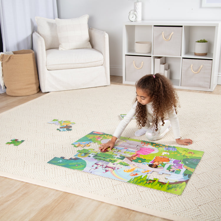 A kid playing with The Melissa & Doug Fairy Tale Castle, Storybook Princess Themed Jumbo Floor Puzzle, 48-Piece Jigsaw Puzzle, 3 x 2 Foot Toddler Puzzles for Kids Ages 3+