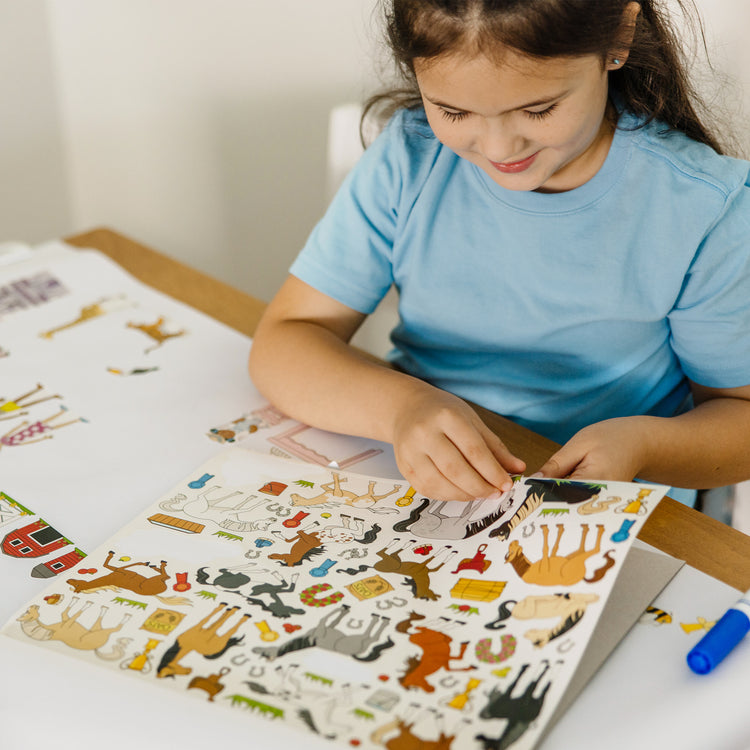 A kid playing with The Melissa & Doug Sticker Collection and Coloring Pads Set: Princesses, Fairies, Animals, and More