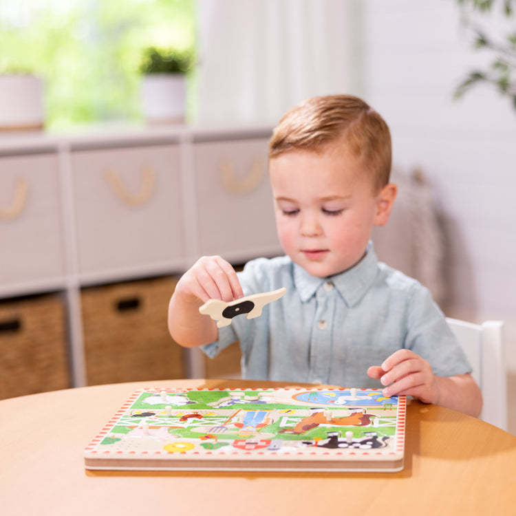 A kid playing with The Melissa & Doug Old MacDonald's Farm Sound Puzzle