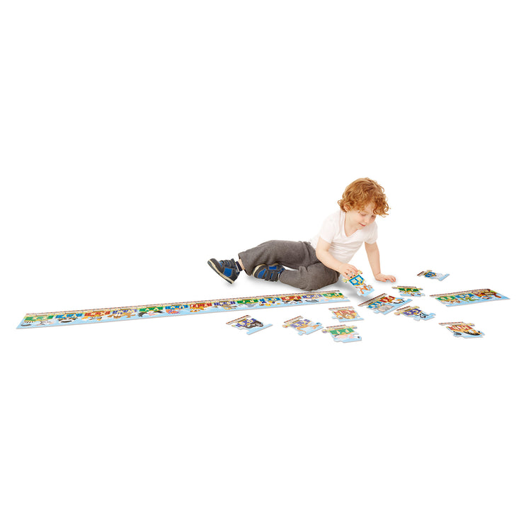 A child on white background with The Melissa & Doug Alphabet Express Jumbo Jigsaw Floor Puzzle (27 pcs, 10 feet long)