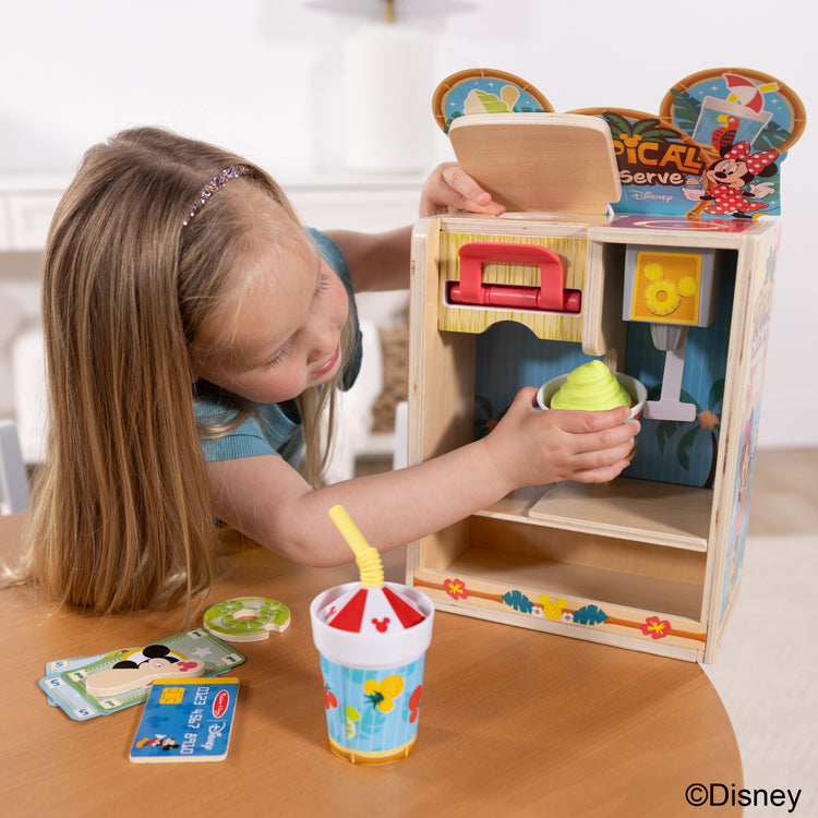 A kid playing with The Disney Tropical Soft Serve Ice Cream Wooden Play Food Set – 23 Pieces | Mickey Mouse, Minnie, Wooden Toy for Boys and for Girls 3+