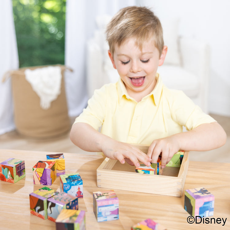 A kid playing with The Melissa & Doug Disney Princess Wooden Toy Cube Puzzle Blocks for Boys and for Girls 3+
