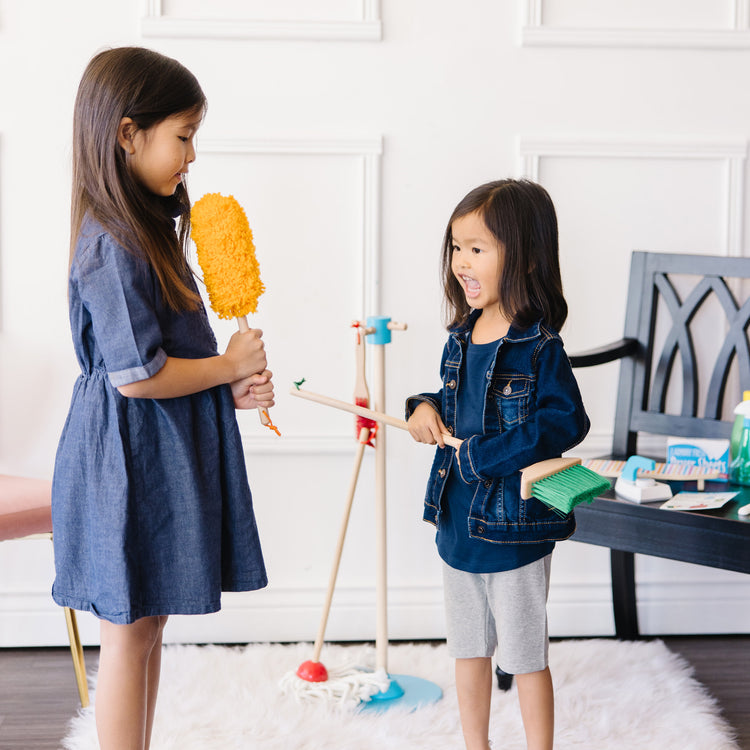 A kid playing with The Deluxe Cleaning & Laundry Play Set