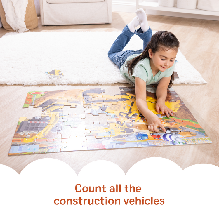 A kid playing with The Melissa & Doug Building Site, Construction Themed Jumbo Floor Puzzle, 48‑Piece Construction Vehicle Jigsaw Puzzle, 3 x 2 Foot Toddler Puzzles for Kids Ages 3+