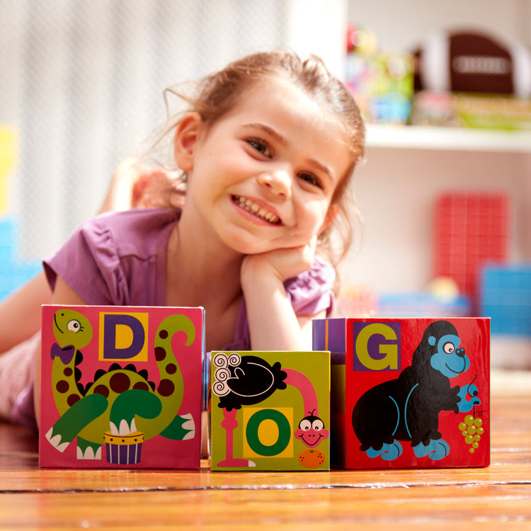 A kid playing with The Melissa & Doug Deluxe 10-Piece Alphabet Nesting and Stacking Blocks