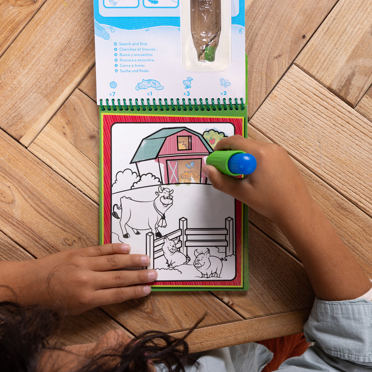 A kid playing with The Melissa & Doug Water WOW! 2-Pack – Animals, Vehicles Water-Reveal Travel Activity Pads 