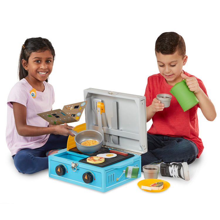 A child on white background with The Melissa & Doug Let’s Explore Camp Stove Play Set – 24 Pieces