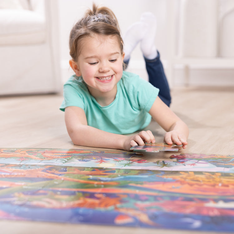 A kid playing with The Melissa & Doug Dinosaurs Jumbo Floor Puzzle, 48-Piece Prehistoric-Themed Jigsaw Puzzle with Dinosaurs and Illustrated Guide, 3 x 2 Foot Kids Puzzles for Toddlers Ages 3+