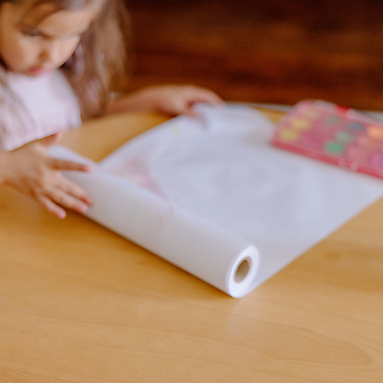 A kid playing with The Melissa & Doug Tabletop Easel Paper Roll (12 inches x 75 feet) - 2-Pack