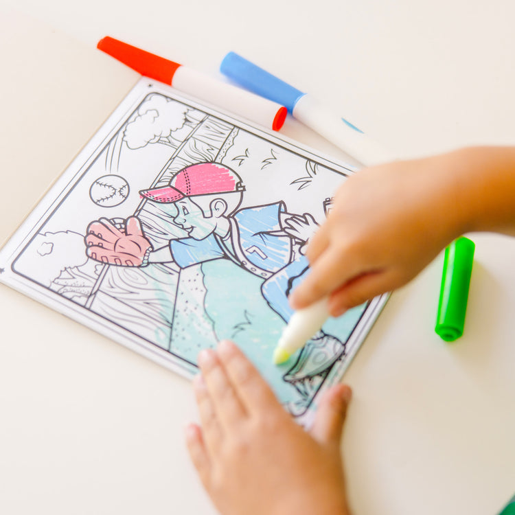 A kid playing with The Melissa & Doug On the Go Magicolor Coloring Pad: Adventure - 18 Coloring Pages and 4 Markers