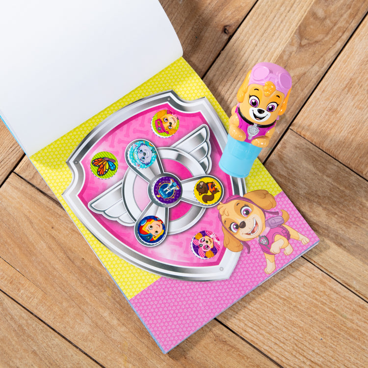 A playroom scene with The Melissa & Doug Sticker WOW!™ 24-Page Activity Pad and Sticker Stamper, 300 Stickers, Arts and Crafts Fidget Toy Collectible Character – PAW Patrol Skye
