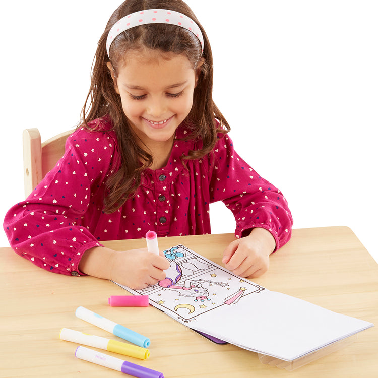A child on white background with The Melissa & Doug On the Go Magicolor Coloring Pad - Princess (18 Pages)