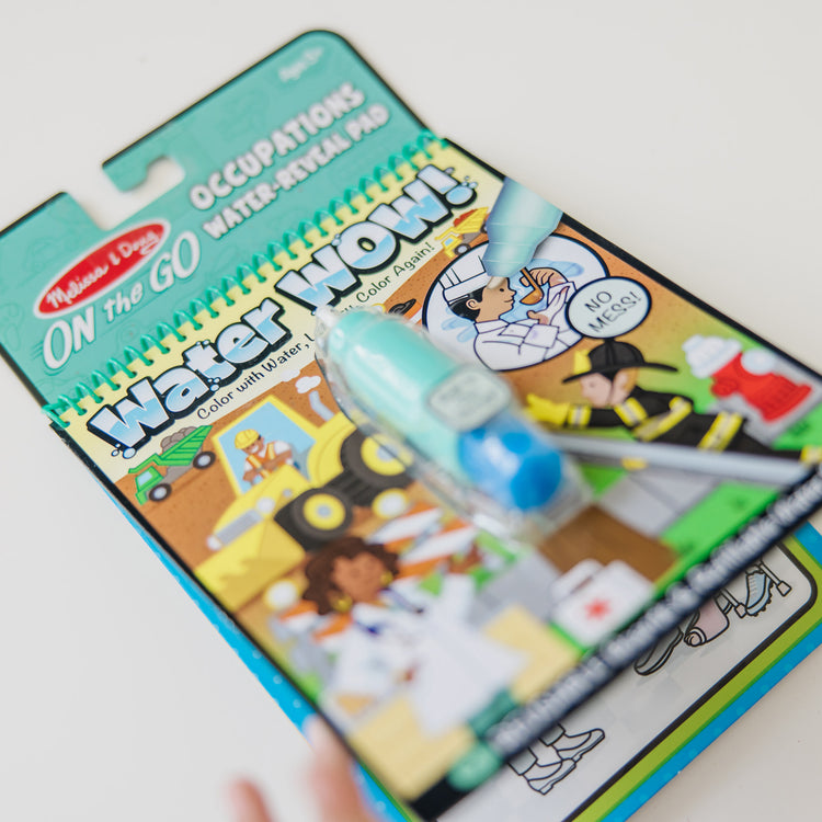 A kid playing with The Melissa & Doug On the Go Water Wow! Reusable Water-Reveal Activity Pad – Occupations