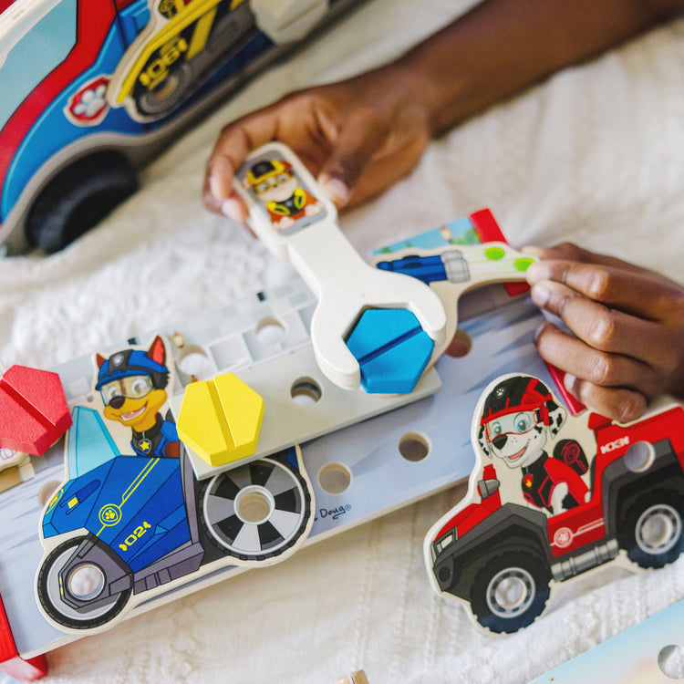 A kid playing with The Melissa & Doug PAW Patrol Match & Build Mission Cruiser