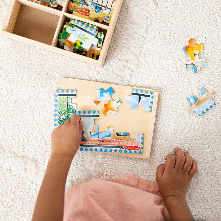 A kid playing with The Melissa & Doug Pets 4-in-1 Wooden Jigsaw Puzzles in a Storage Box (48 pcs)