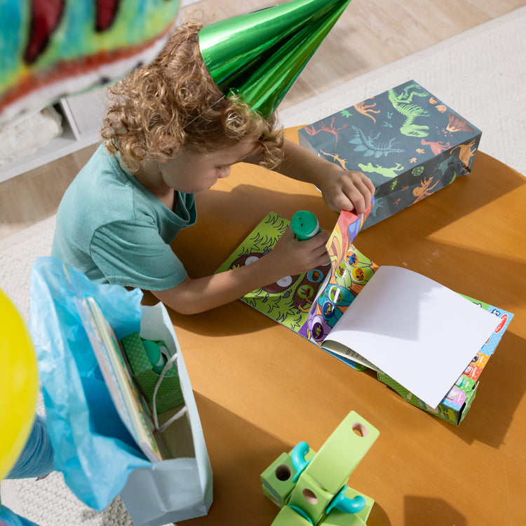 A playroom scene with The Melissa & Doug Sticker WOW!™ 24-Page Activity Pad and Sticker Stamper, 300 Stickers, Arts and Crafts Fidget Toy Collectible Character – Dinosaur