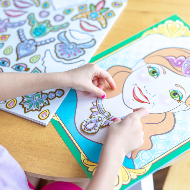 A kid playing with The Melissa & Doug Make-a-Face Sticker Pad: Sparkling Princesses - 15 Faces, 4 Sticker Sheets