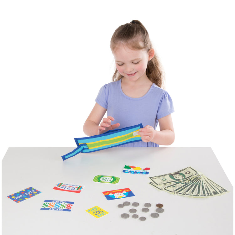 A child on white background with The Melissa & Doug Pretend-to-Spend Toy Wallet With Play Money and Cards (45 pcs), Blue