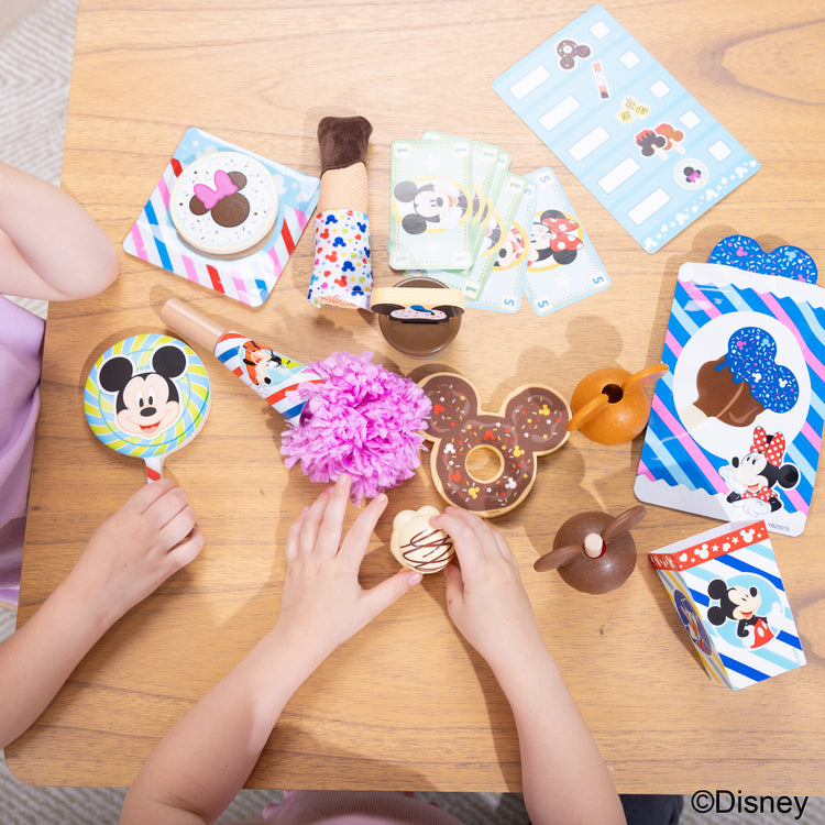 A kid playing with The Melissa & Doug Disney Snacks & Popcorn Wooden Play Food Set – 24 Pieces | Mickey Mouse, Minnie, Wooden Toy for Boys and for Girls 3+