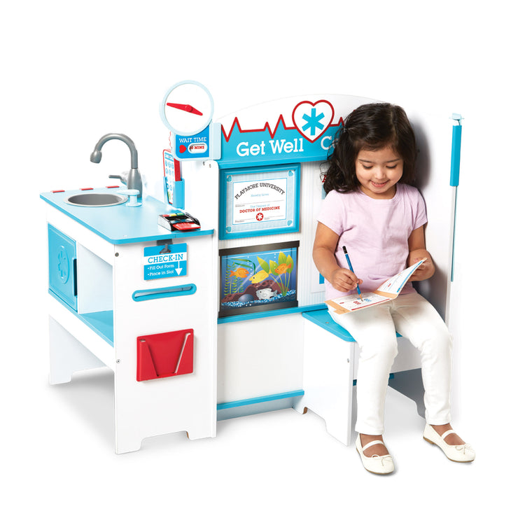 A child on white background with The Melissa & Doug Wooden Get Well Doctor Activity Center - Waiting Room, Exam Room, Check-In Area