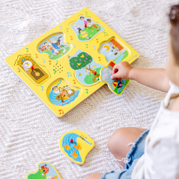 A kid playing with The Melissa & Doug Nursery Rhymes 1 Sound Puzzle - 6 PIeces