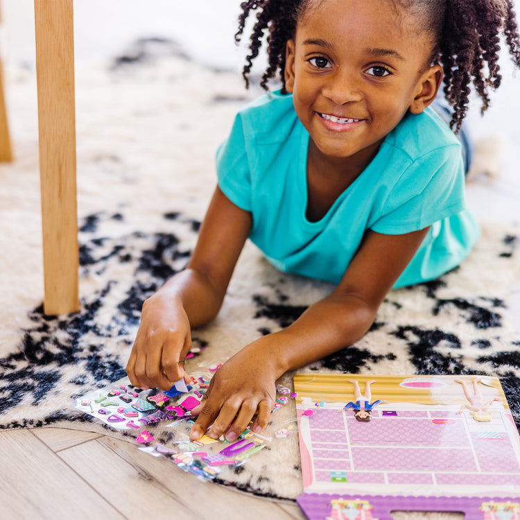 A kid playing with The Melissa & Doug Puffy Sticker Activity Book: Dress-Up - 76 Reusable Stickers