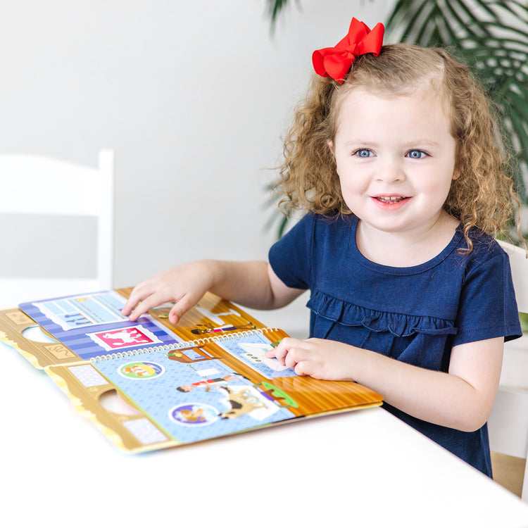 A kid playing with The Melissa & Doug Pet Shop Puffy Sticker Set With 115 Reusable Stickers